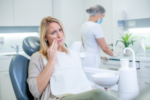 Blonde woman with tooth pain visiting emergency dentist